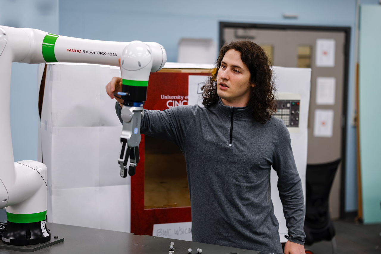 James Talavage examines a robotic arm in an engineering lab.