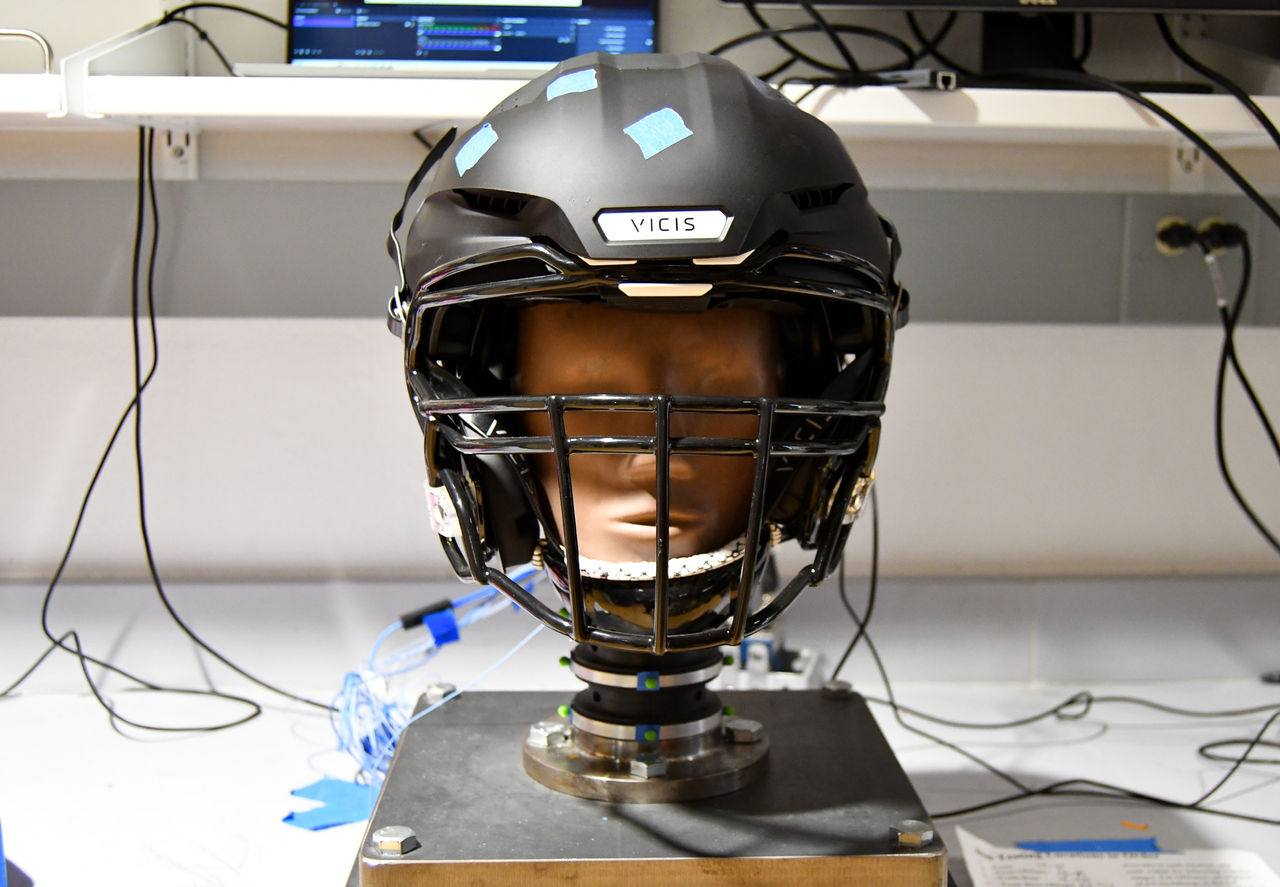 A football helmet over a dummy head mounted with sensors.