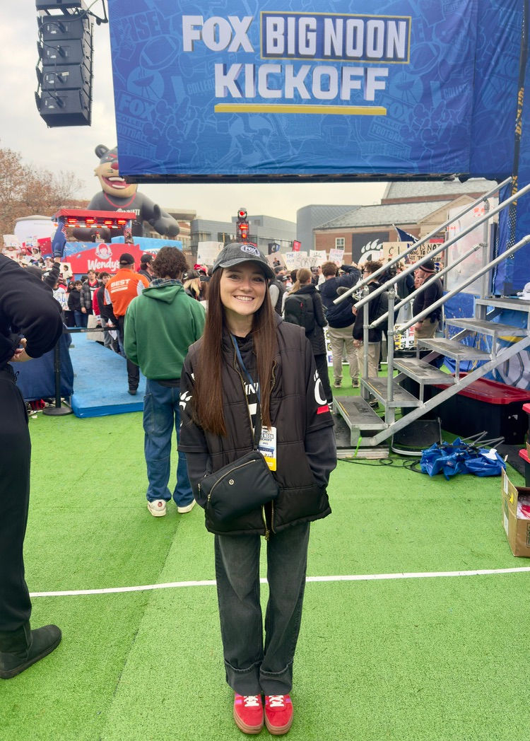 Hannah Laman in front of a large FOX Big Noon Kickoff sign. 