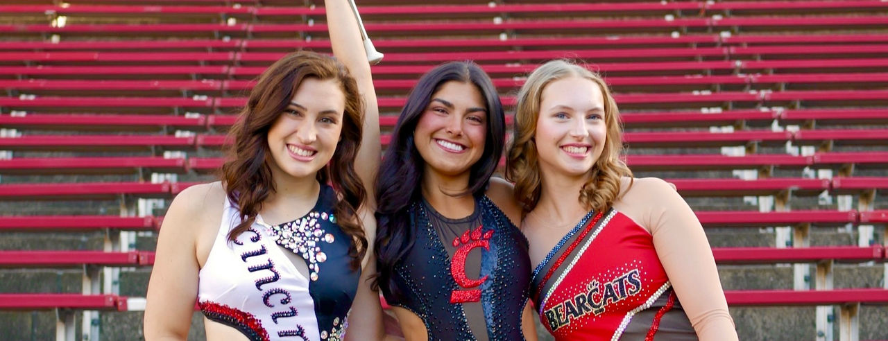 Left to right: Erienne Hay, Lexi Peats, and Darla Kern sit in the bleachers at Nippert Stadium