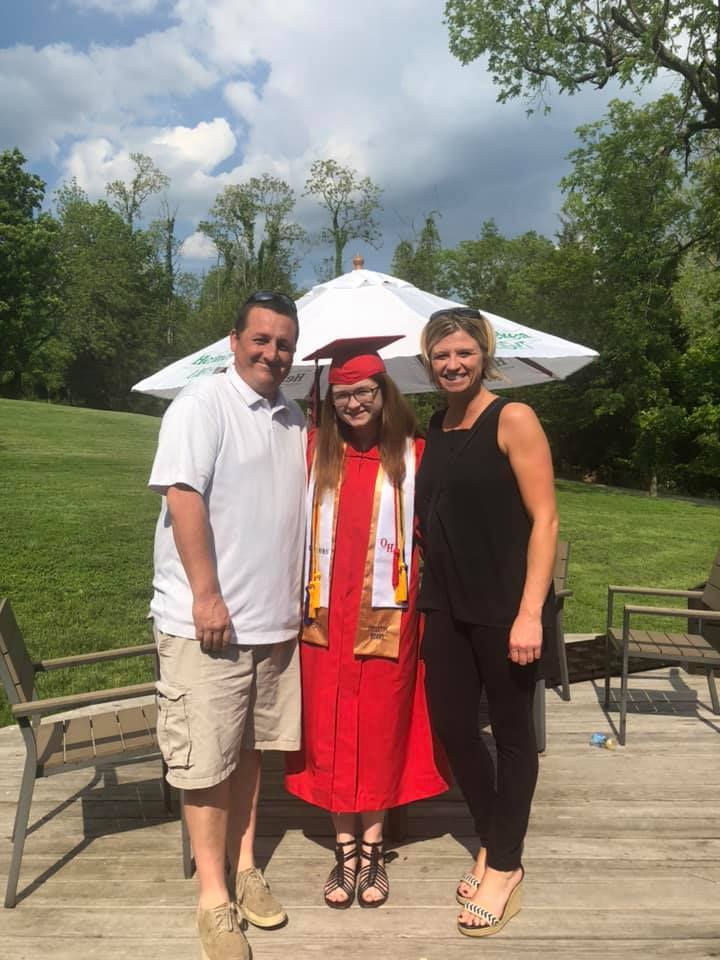 Bearcats for Life Melissa Buckley in a cap and gown with her parents