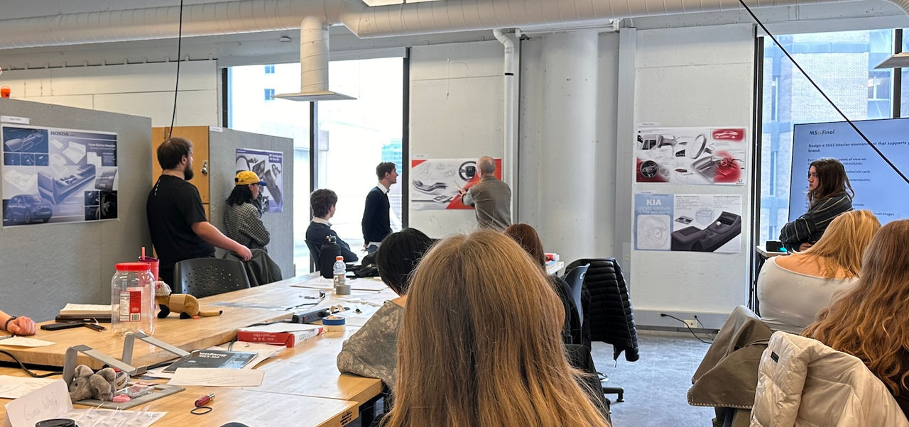 image of a classroom with students working with professor