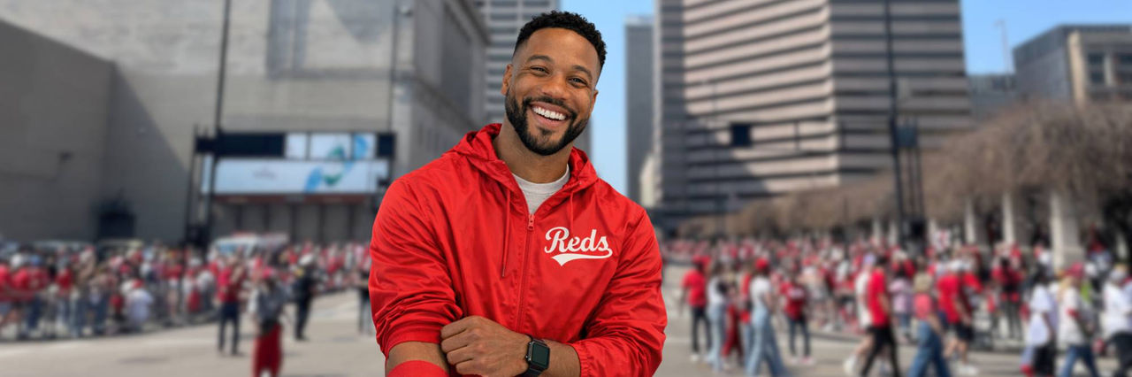 Reds windbreaker on man with downtown Cincinnati in background