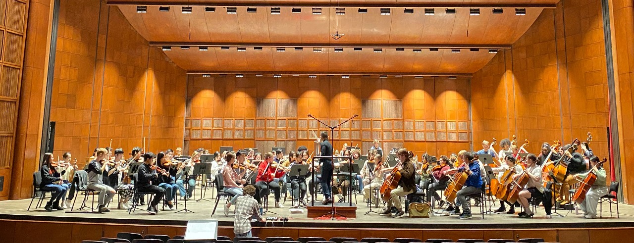 A CCM student orchestra on stage during a film scoring class recording project.