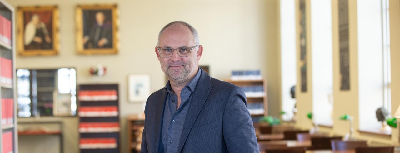 Steven Ellis poses for a photo in Blegen Library.