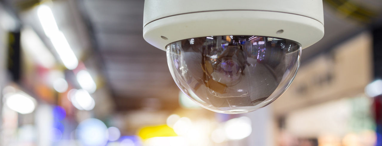 A security camera with blurry retail environment in the background