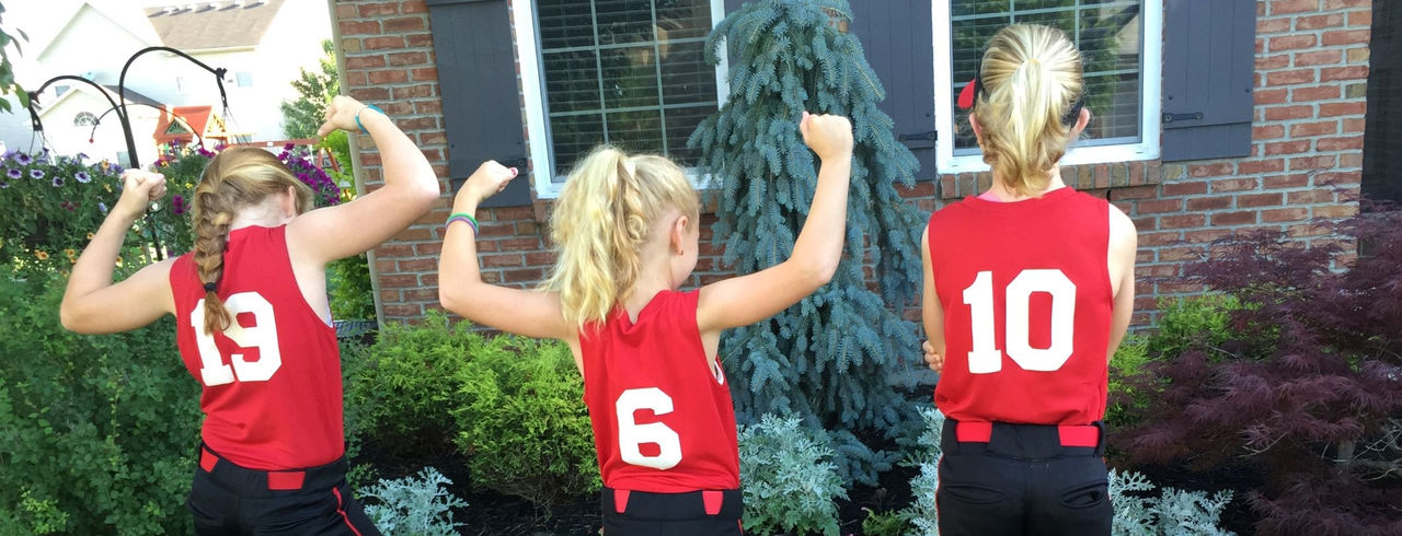 the three enginger sisters showing their softball uniform