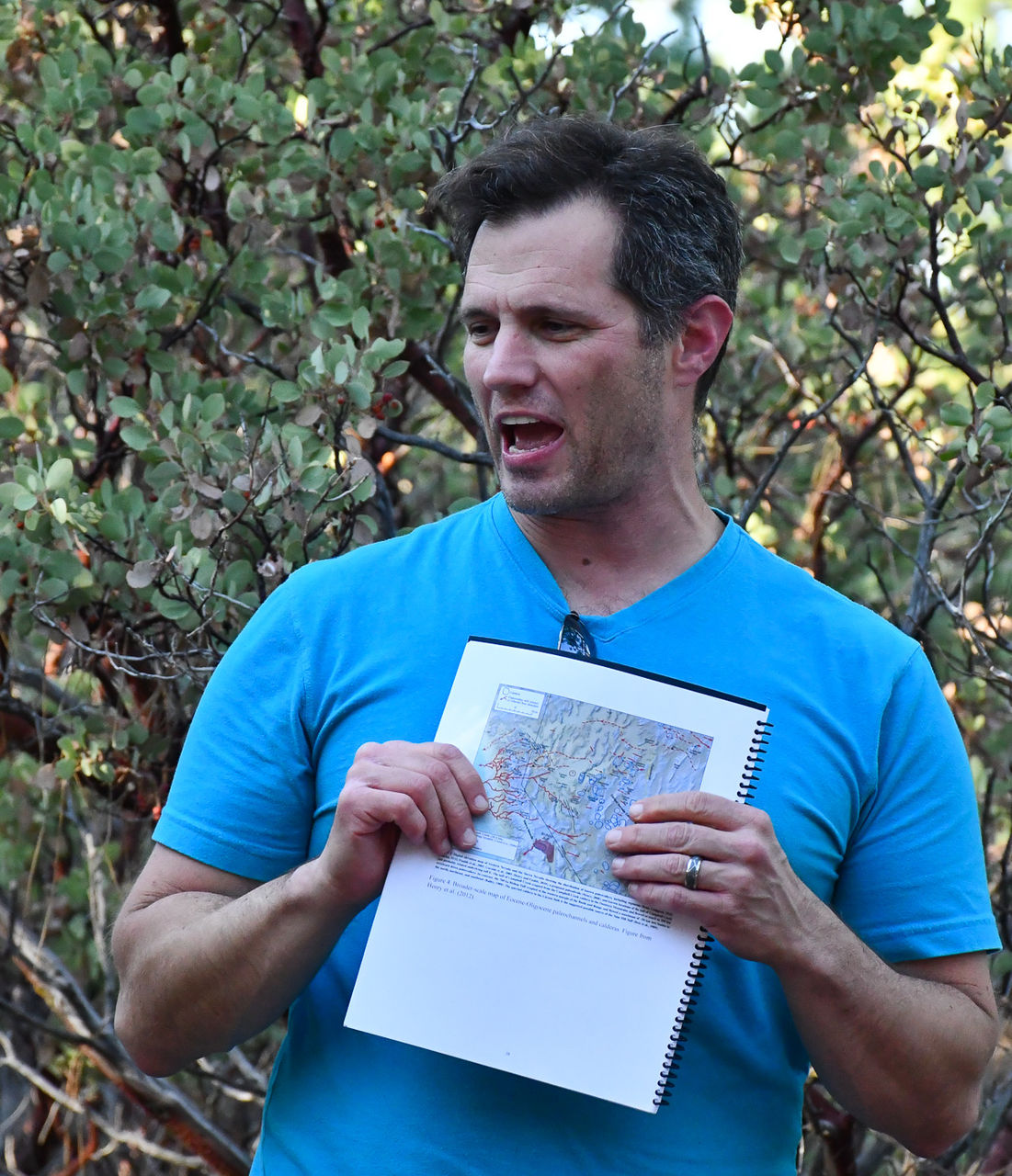 Daniel Sturmer holds up a map while talking to students.