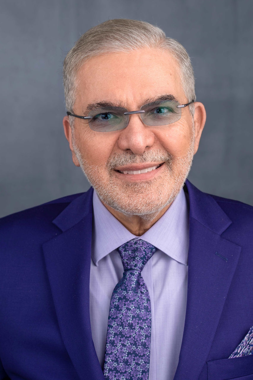 Photo of Henry Nasrallah wearing a suit.