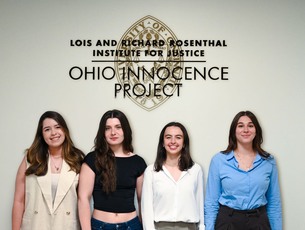 LLM graduates stand in front of OIP offices