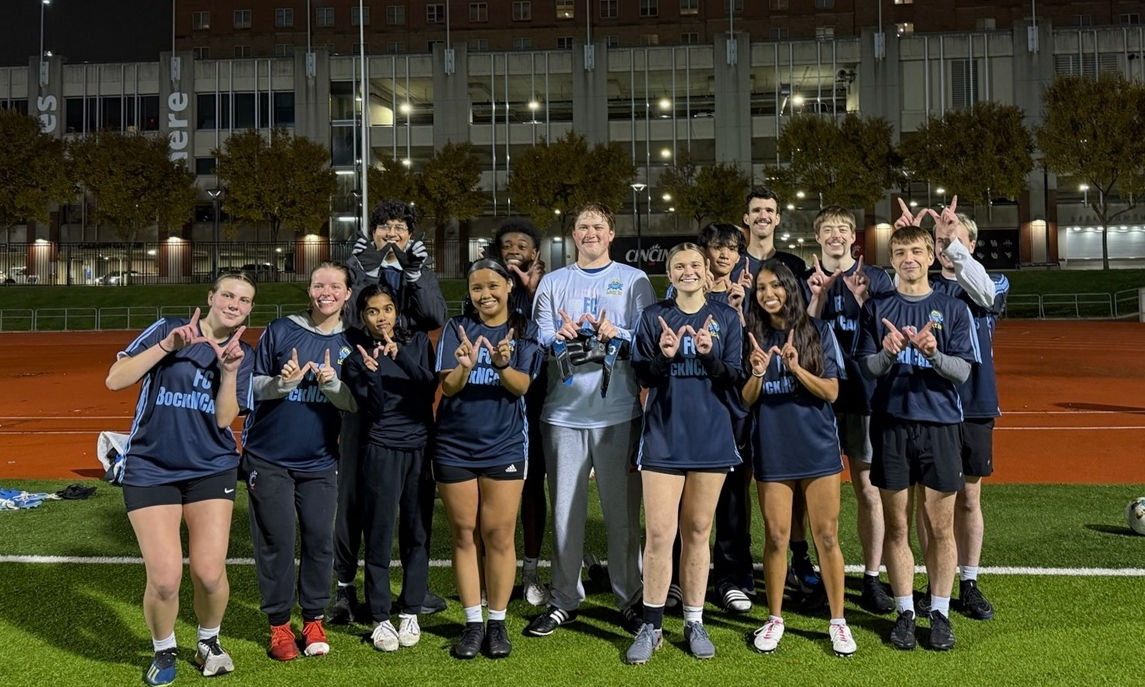 Alex Knapp and his friends post on an athletic field after a game