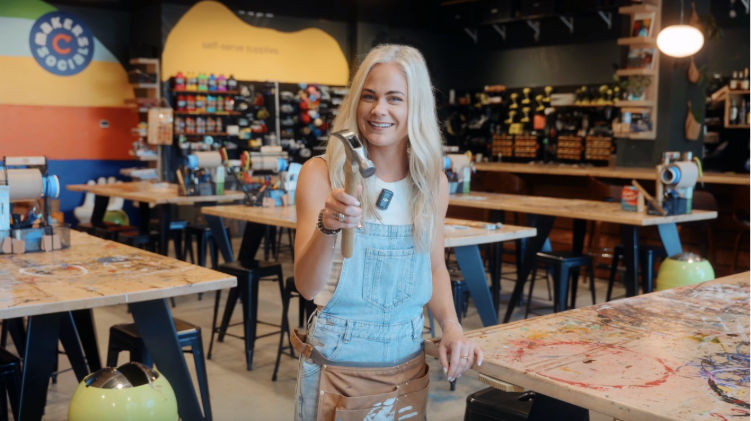 UC co-op alum Megan Pando, founder of Makers Social DIY project bar, smiling in her creative workspace