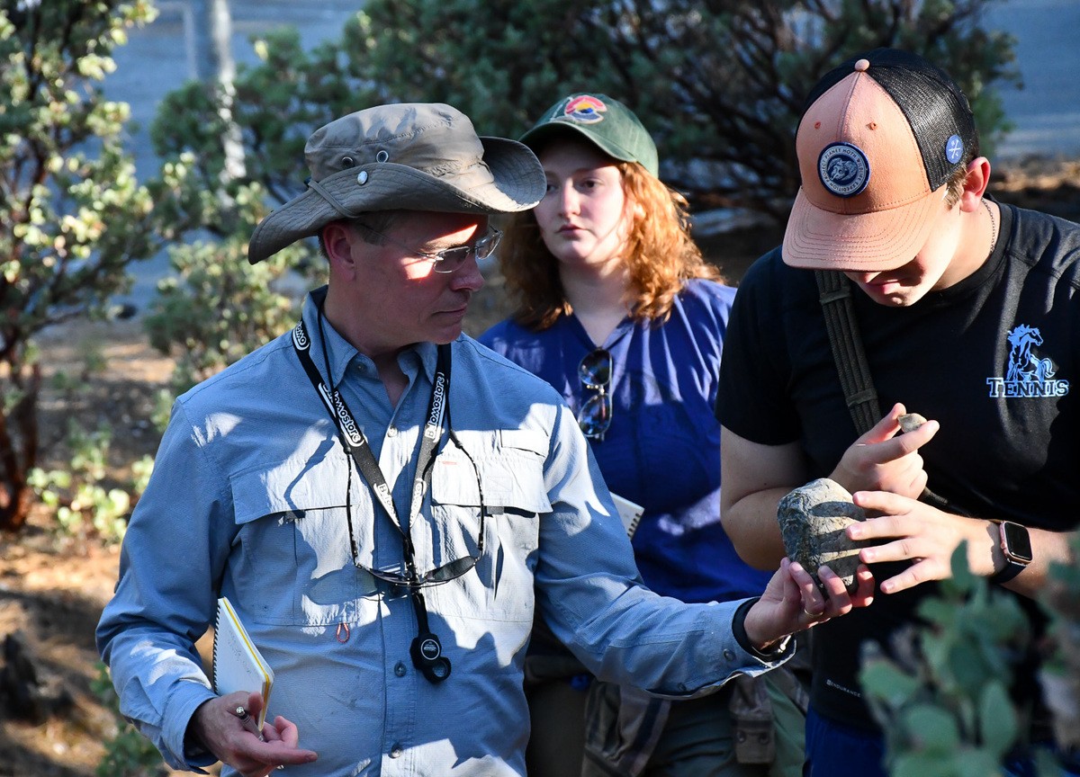 Paul Smith and another student study a rock they collected in California.