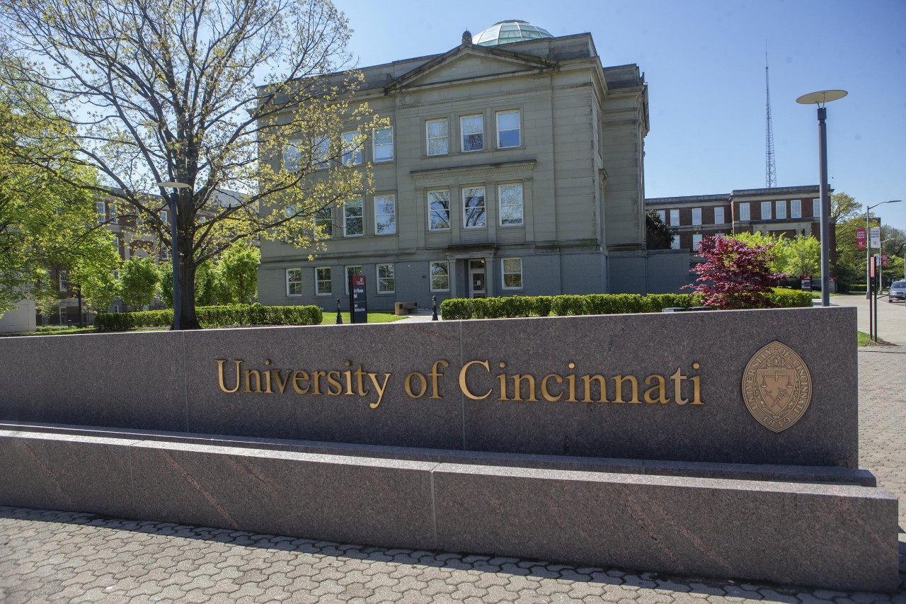 Exterior of shot of Van Wormer Hall with UC sign in the foreground. 