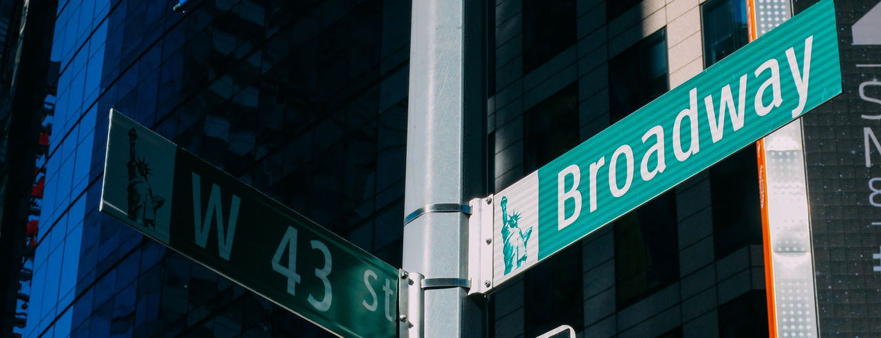 New York Manhattan street crossroad junction road sign featuring Broadway street. 