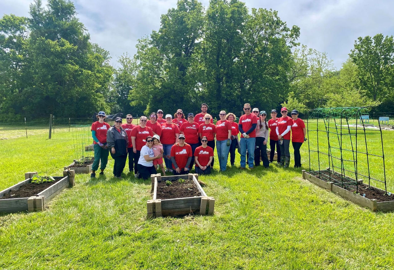 More than two dozen volunteers pose admist planters at the UC Clermont Community Garden.