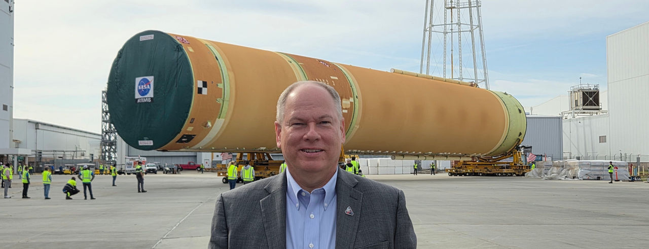 John McCullough in front of a large portion of the Artemis space shuttle 