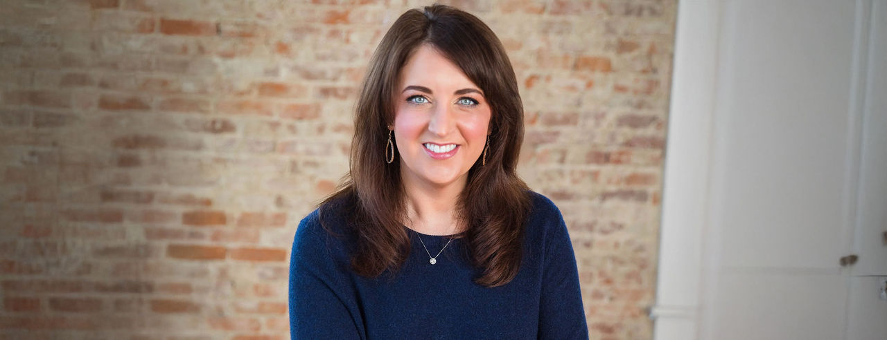 Ashley Payne in a room with a brick wall background