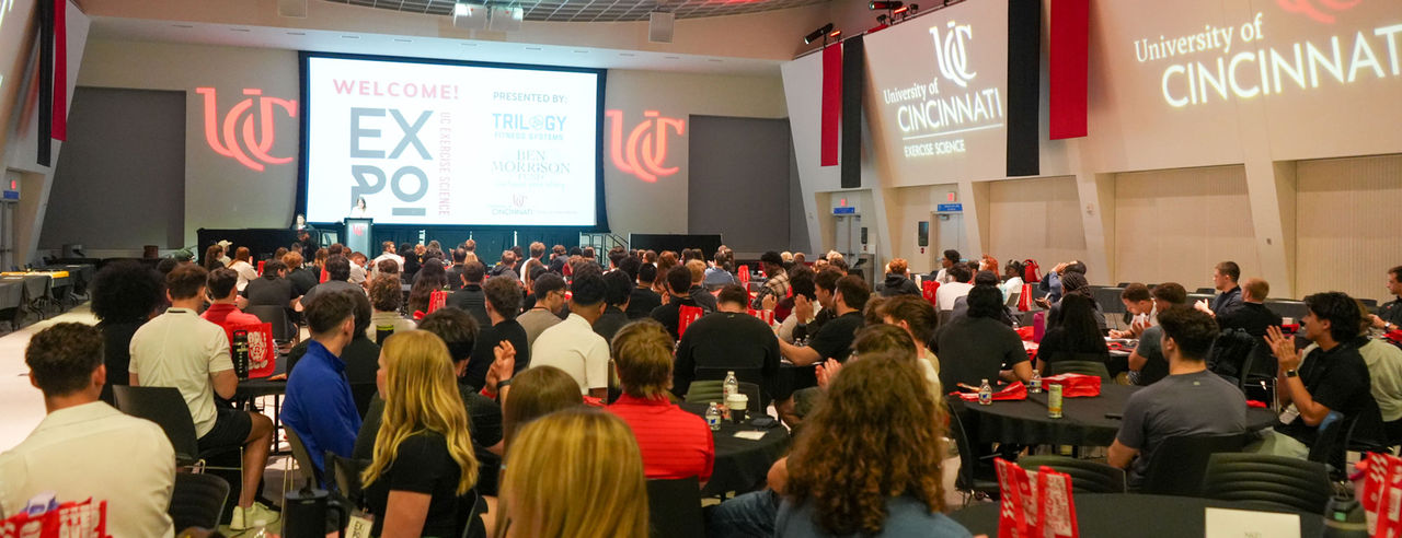 Roomful of people sit before a screen that says welcome uc exercise science expo