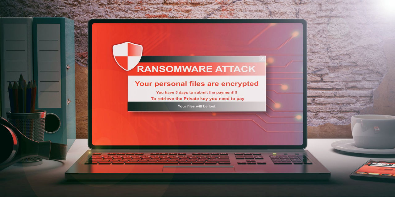 Laptop with a sign that has a ransomware warning on it