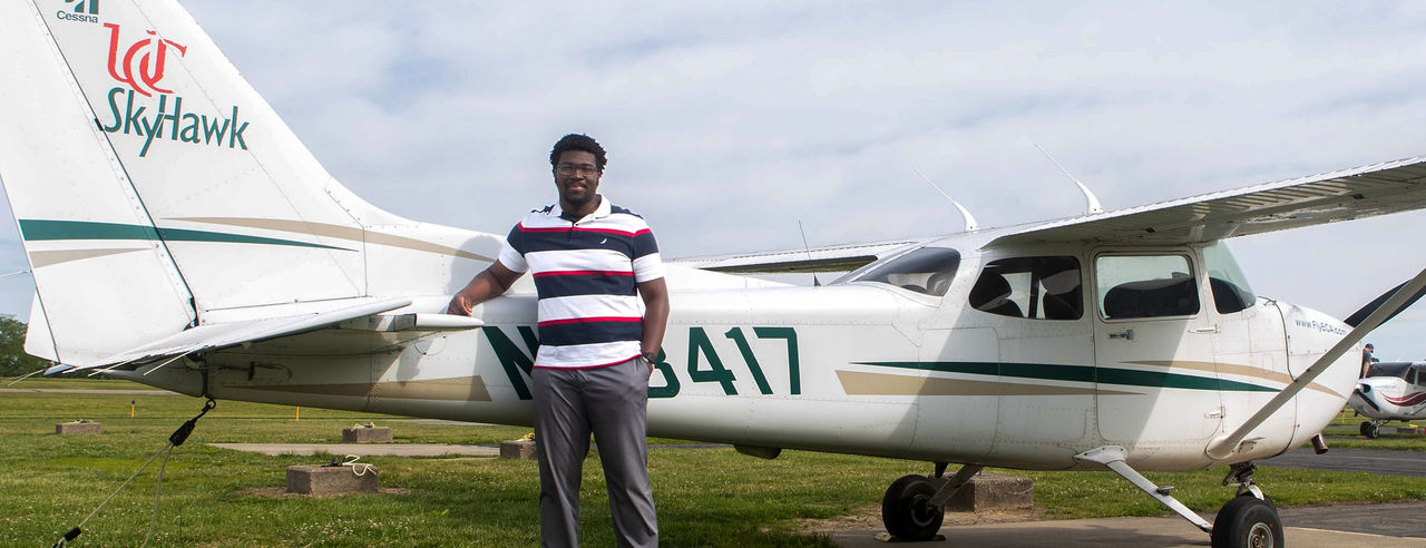 UC Clermont aviation student Glenn Adusei-Poku stands in front of an airplane. 
