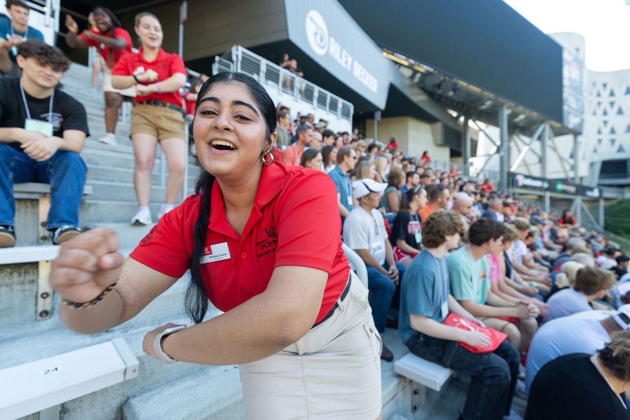 Student Orientation Leader does a rendition of down the drive as a crowd of parents and students are shown in the background