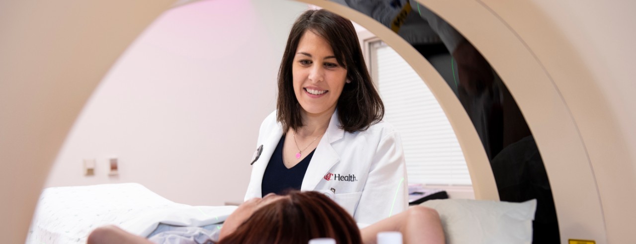 Emily Daugherty looking at a patient a CT machine. She is the lead co-investigator on a first-of-a-kind FLASH radiation therapy study looking at safety of the treatment for cancer that has spread to the bones in the chest.