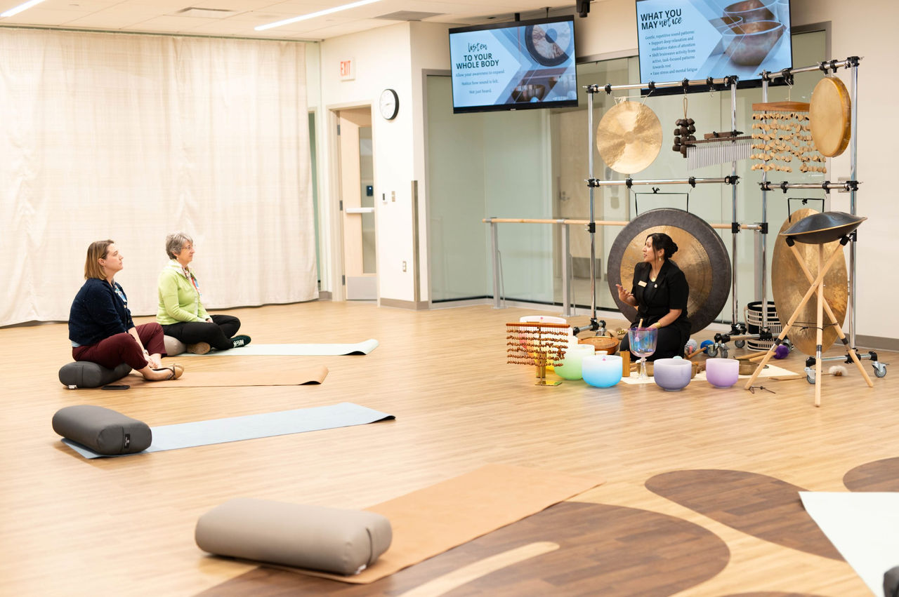 People in a class, sitting on mats.