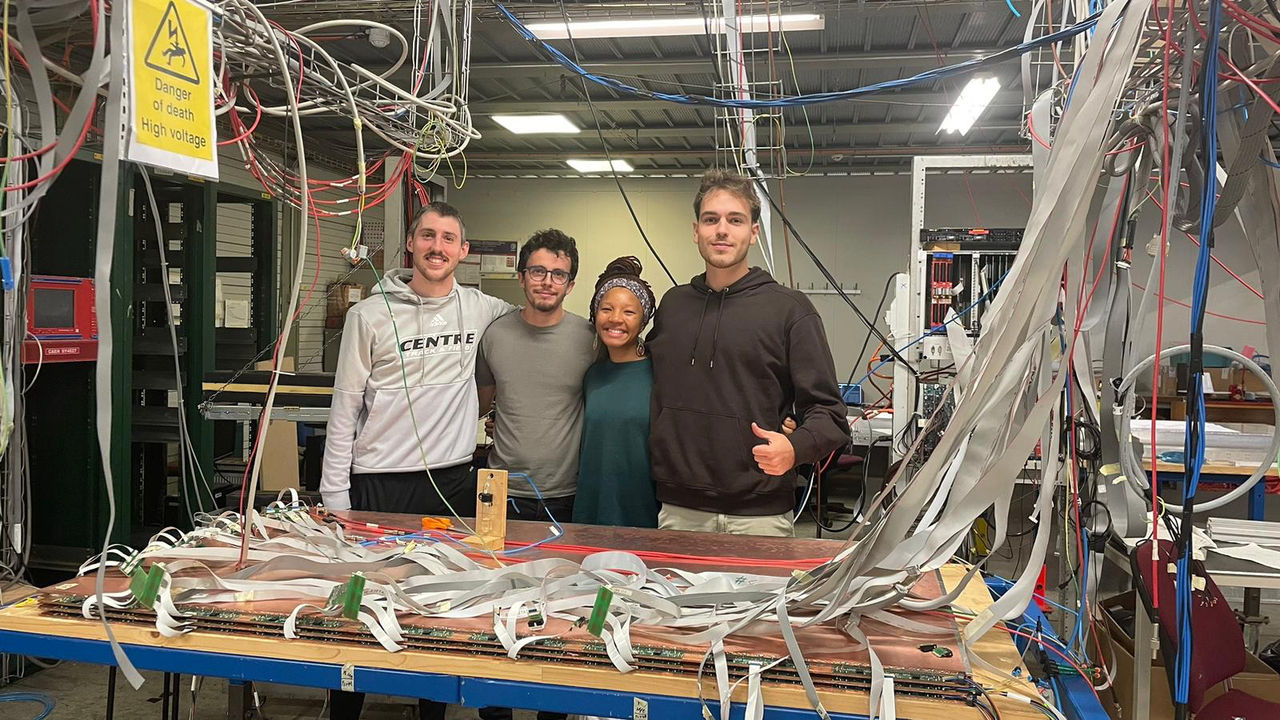 UC students pose over the detector they built.