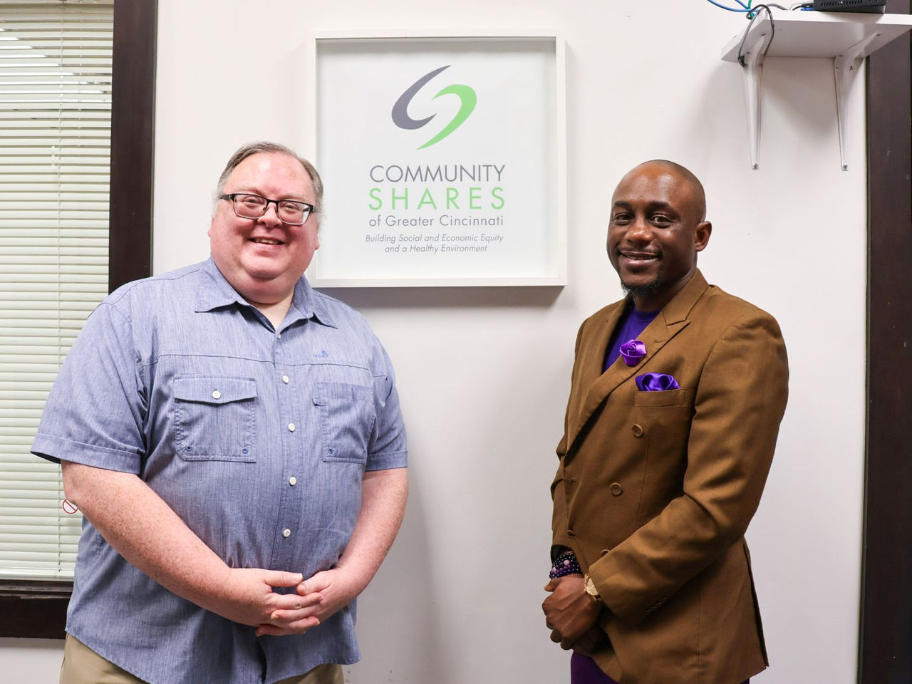 two men standing in front of local business sign