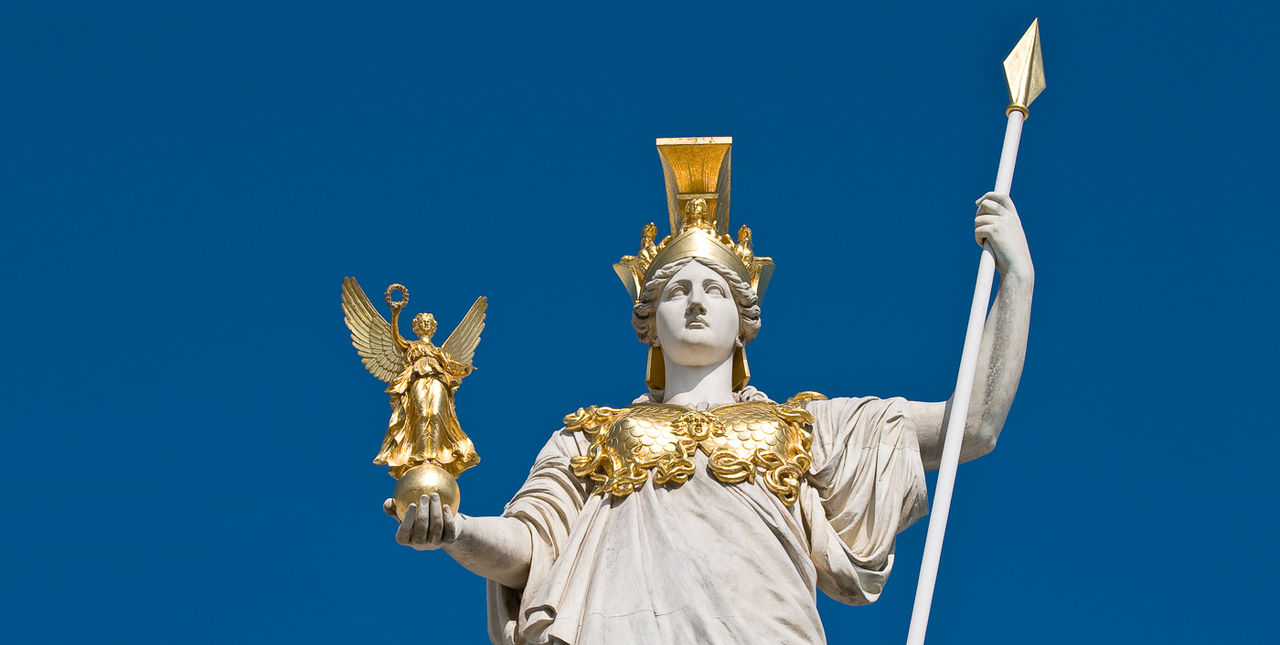 A statue of Athena holding a spear and an idol of Nike.