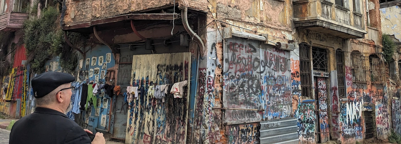 Image of Joseph about to take a picture of an abandoned building covered with graffiti 