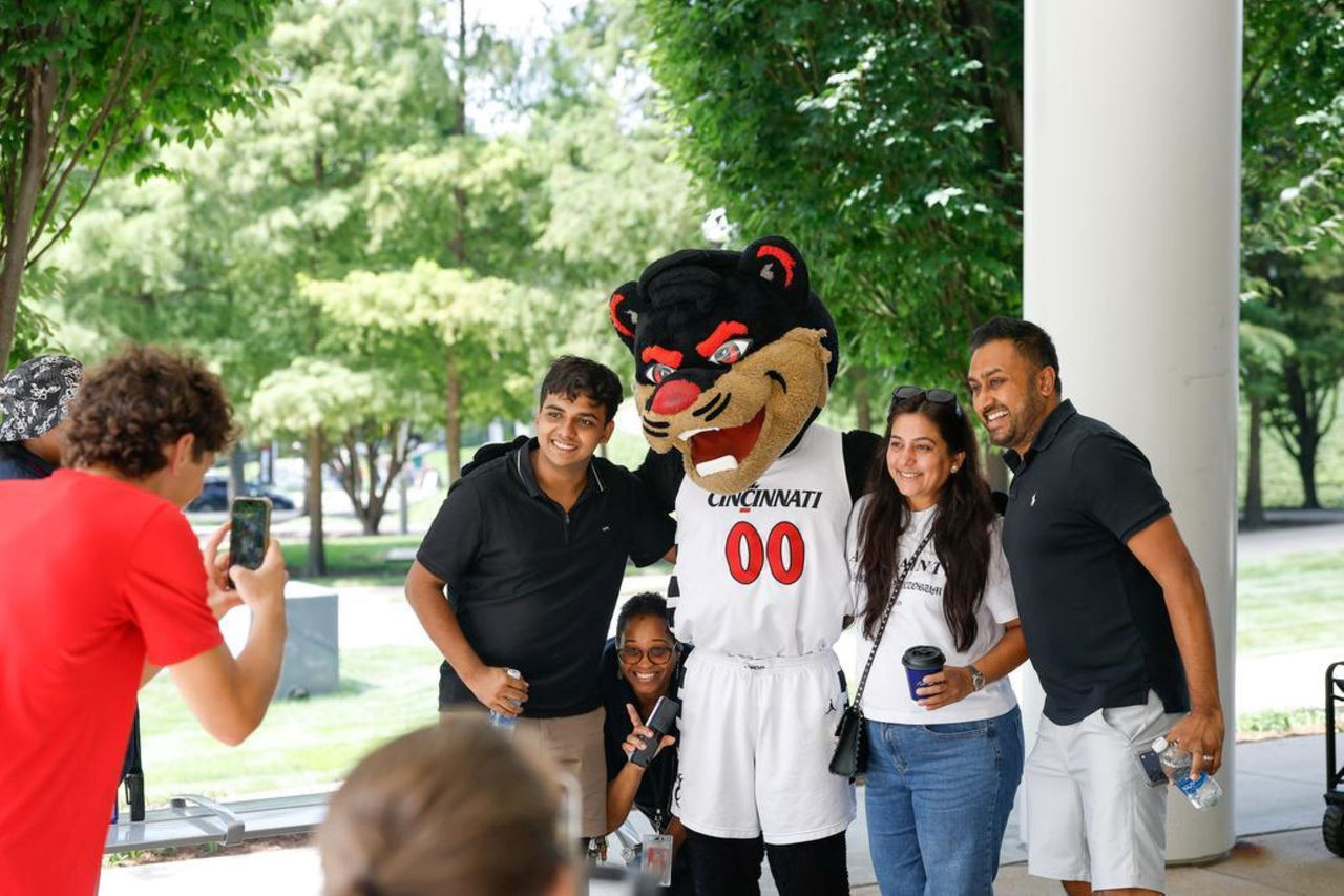 A UC family joins the Bearcat Mascot for a selfie photo