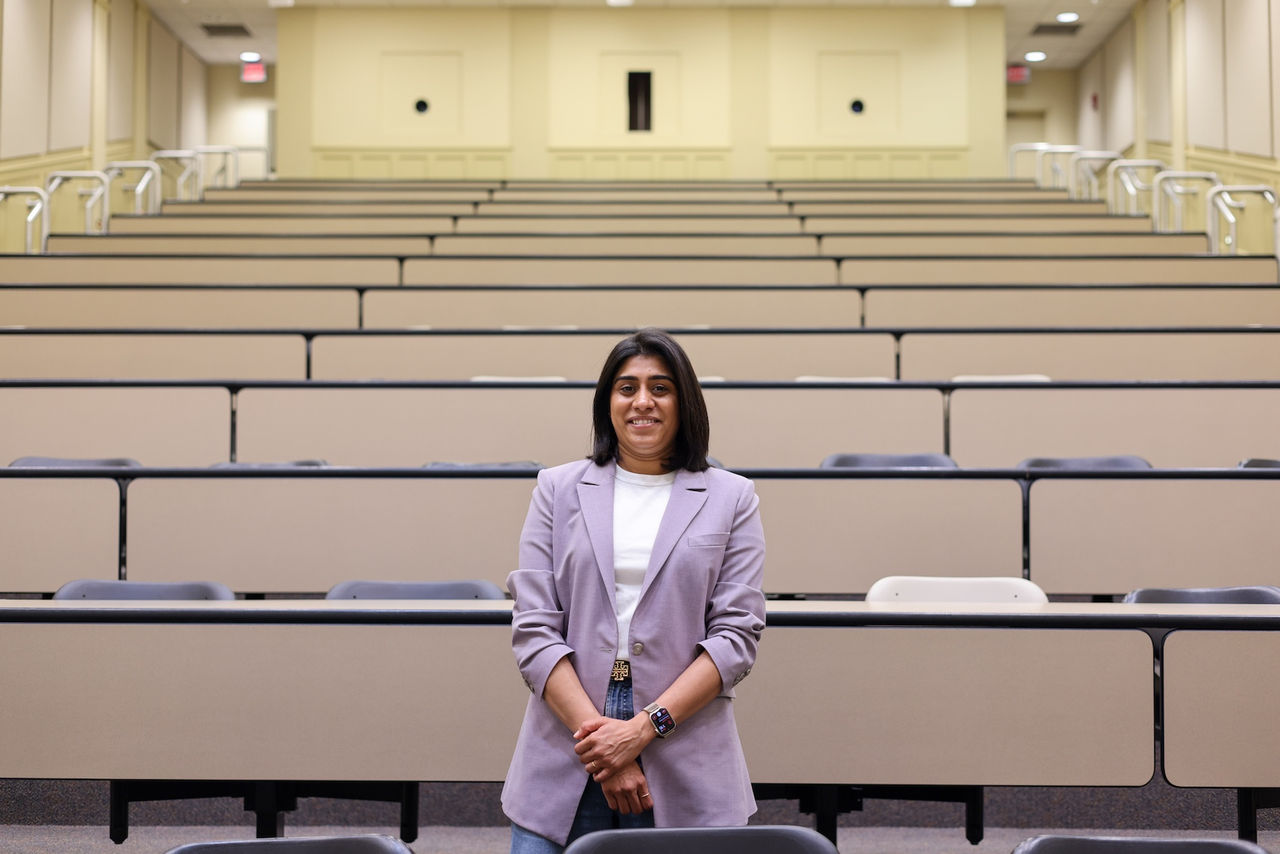 Dhuree Seth stands in a lecture hall 