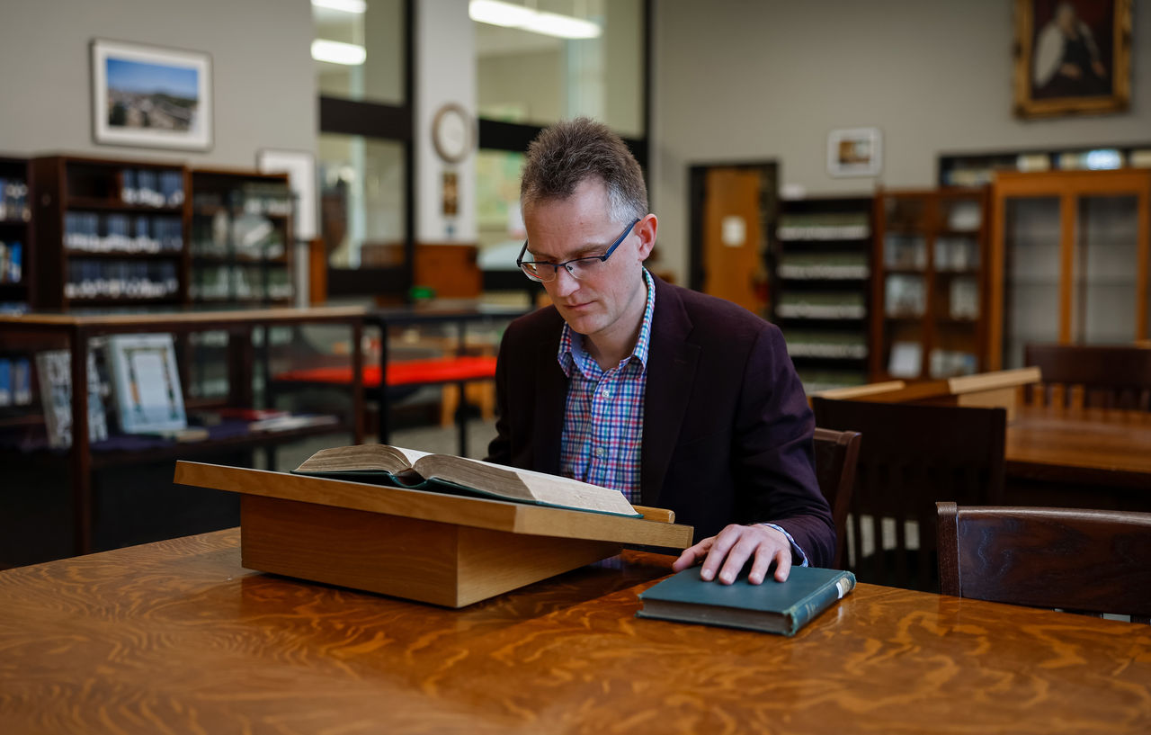 Matthijs Wibier reads a book in the Blegen Library.
