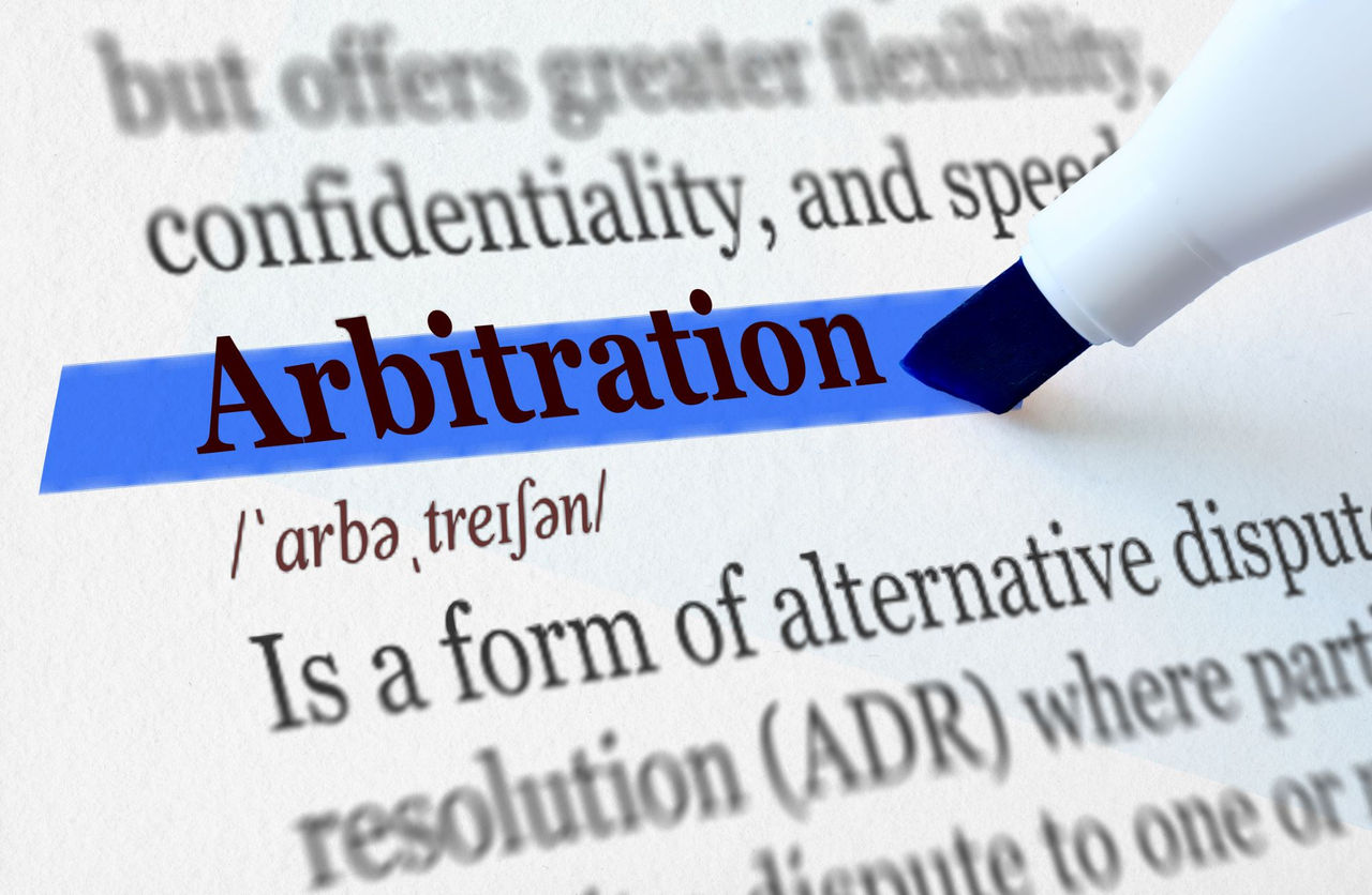 image of the word Arbitration with the definition of the word written out on a page