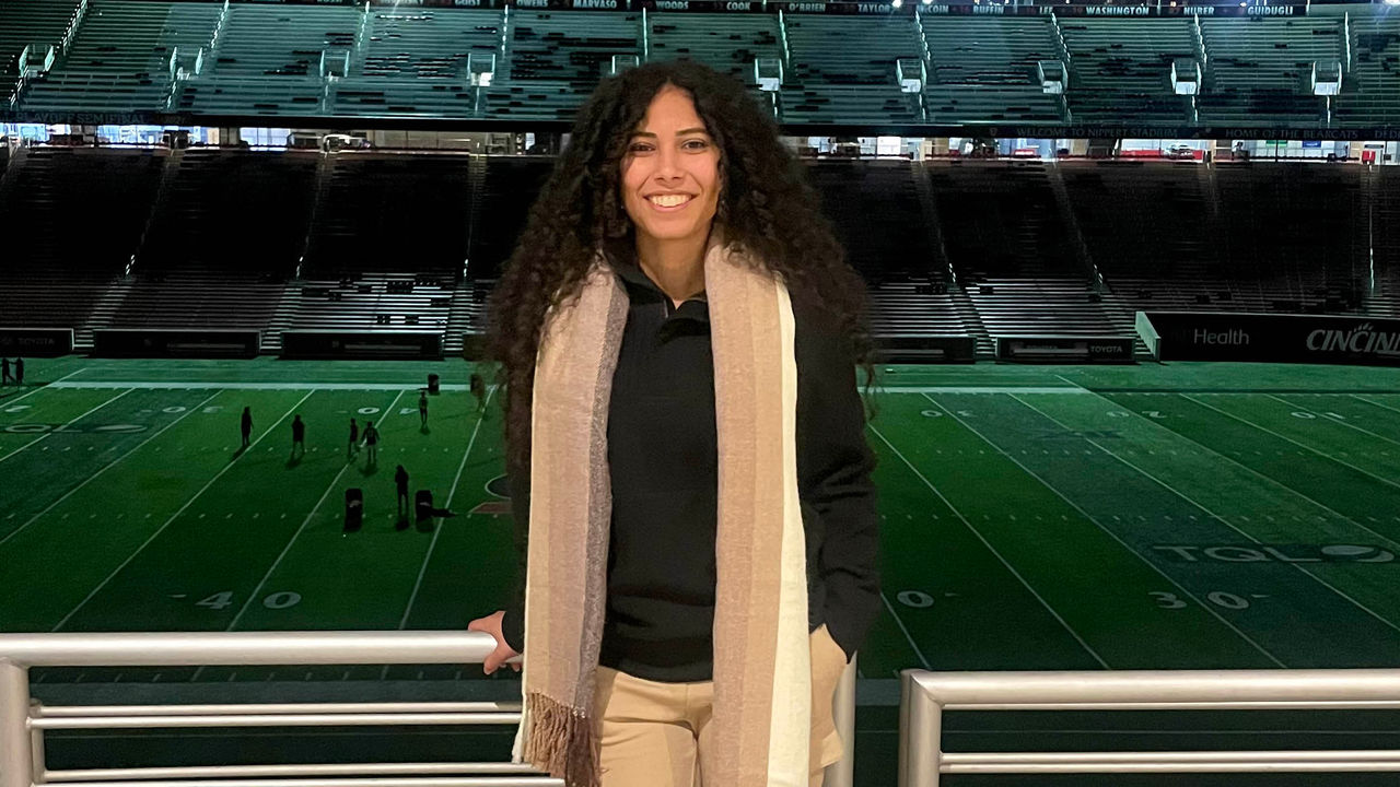 Smiling woman standing in front of stadium at night