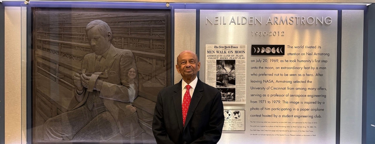 Dinesh Keskar poses in front of the Neil Armstrong Display on campus