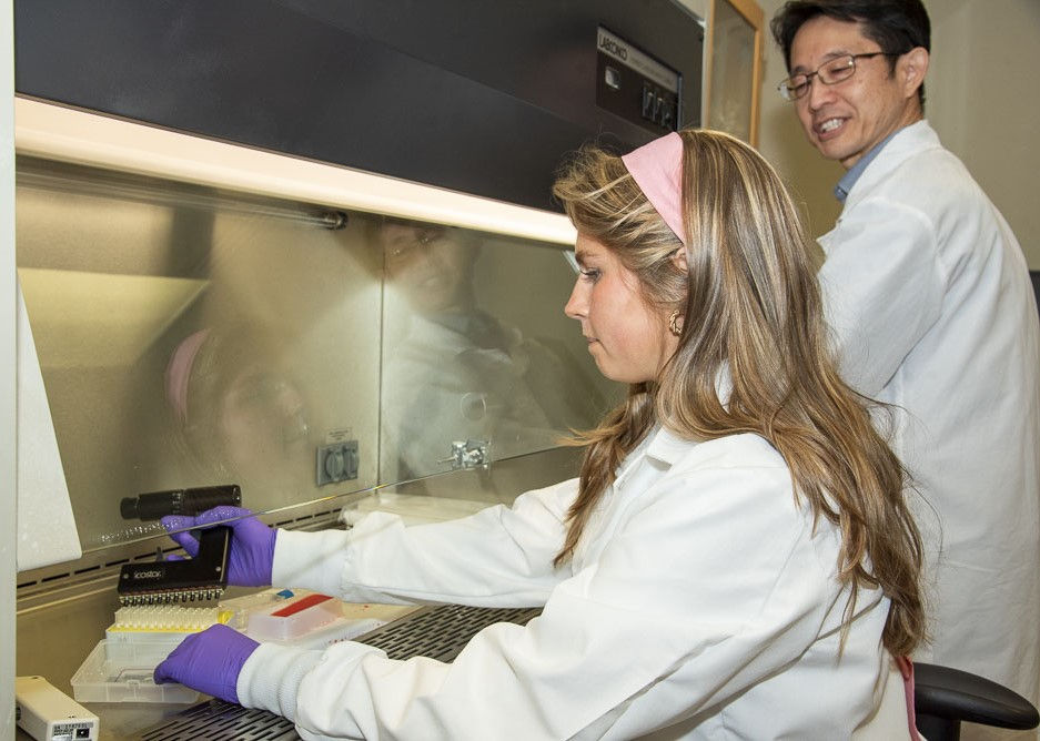 female student with professor in biology lab