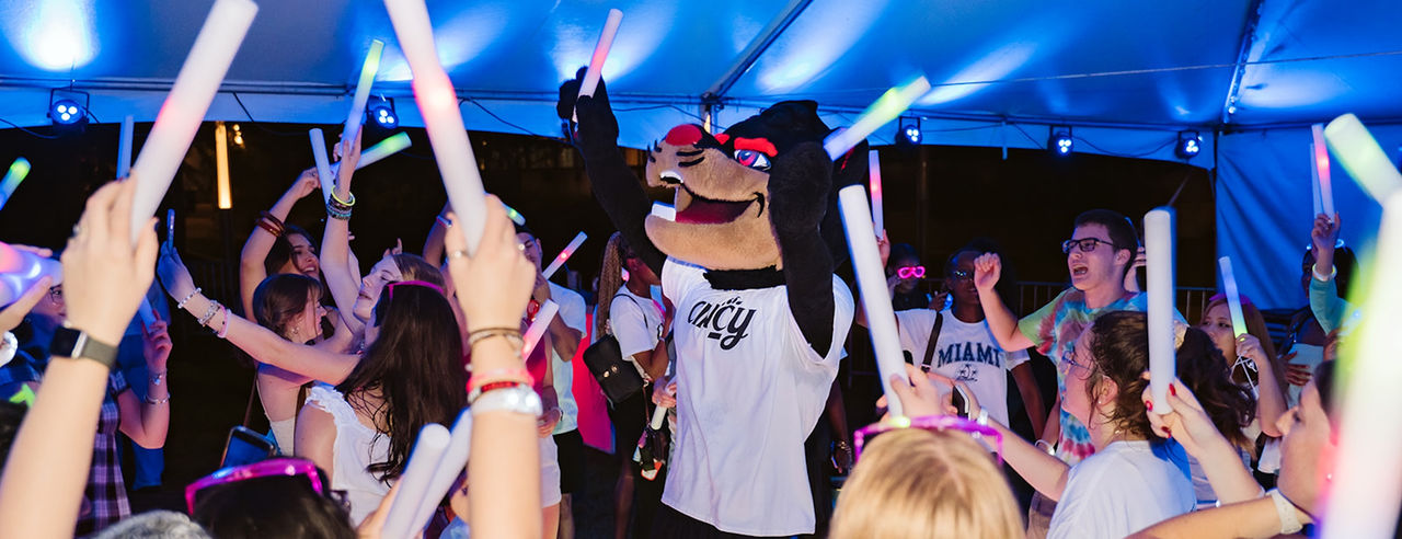 The UC Bearcats mascot dances with students during the Bright Beginnings glow party