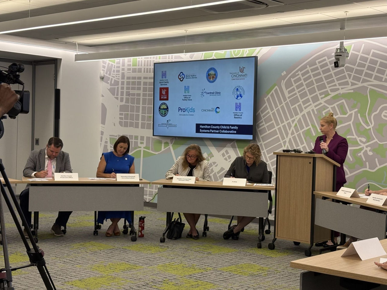 Representatives of four organizations are seen signing paperwork for the newly formed Hamilton County Child & Family Systems Partner Collaborative