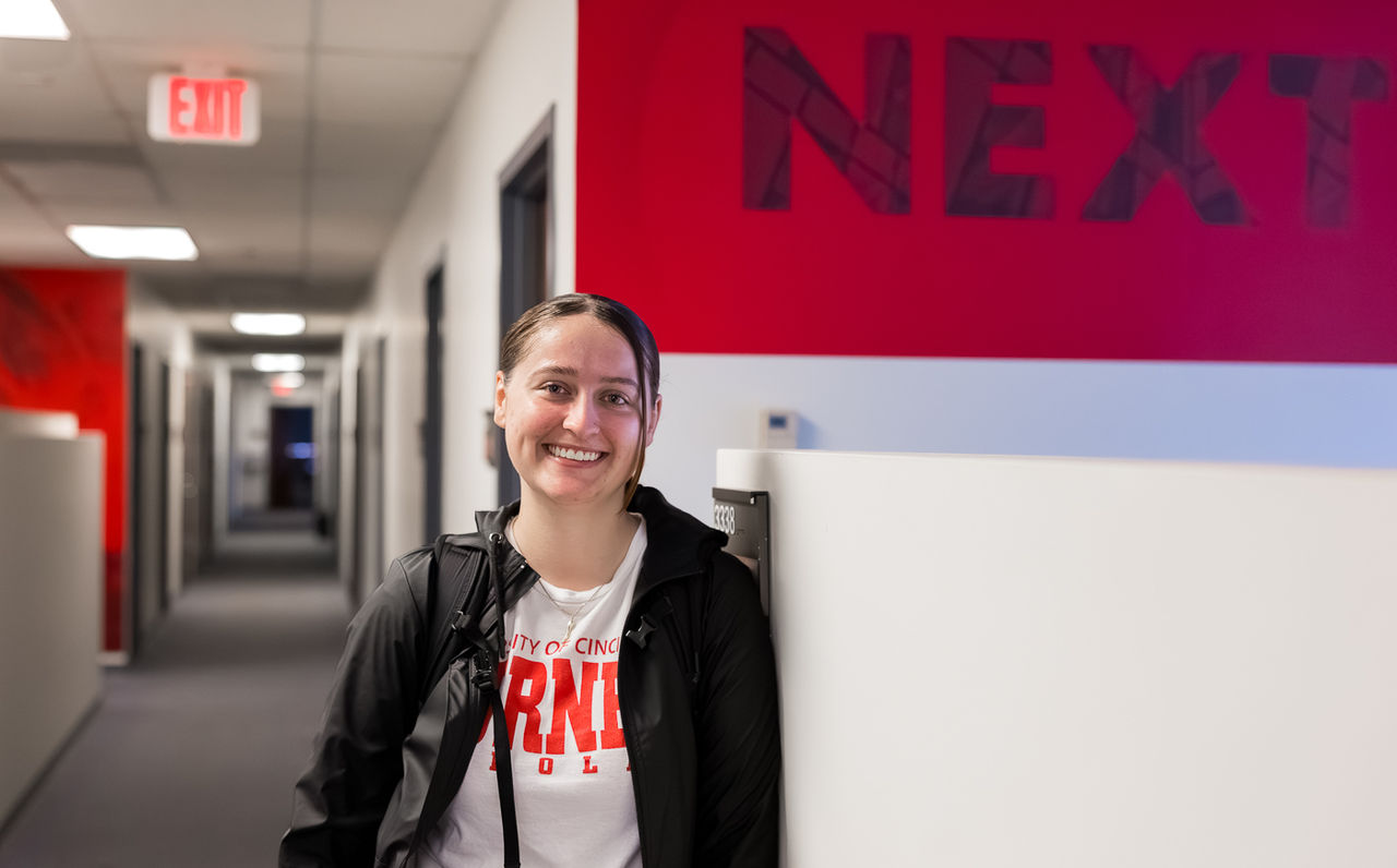 Emma Korman poses under a banner that reads Next.