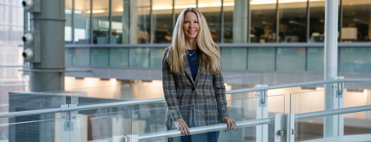 Natalie Kreitzer, MD, stands on a glass walkway on the medical campus