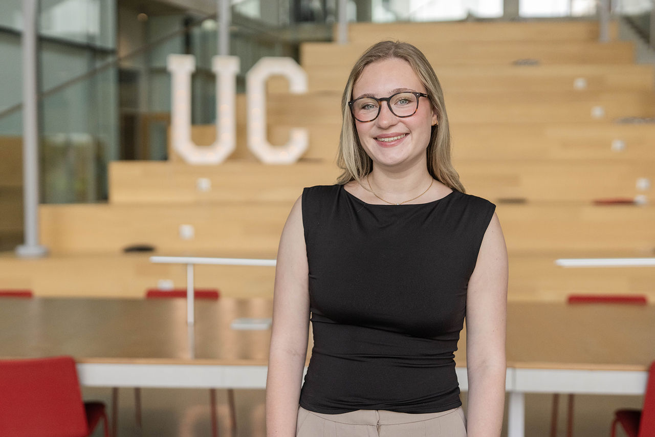 Amelia Wares in front of UC sign.