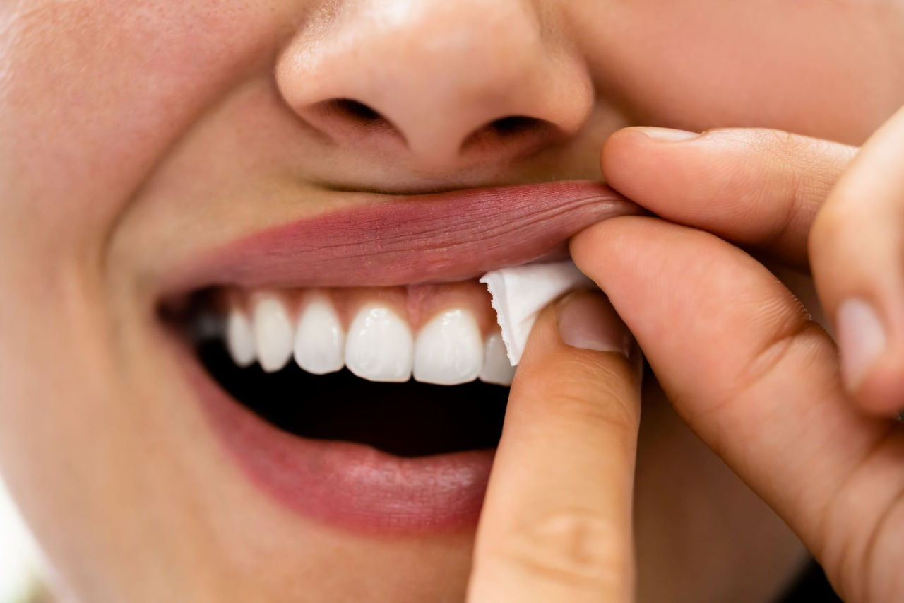 Close up of woman placing nicotine pouch under her lipes