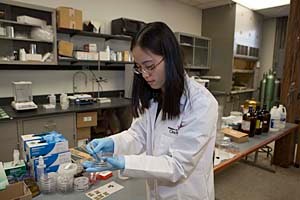 Yan Jin, a UC doctoral student in the materials science and engineering program, is photographed in a lab in the College of Engineering and Applied Science.