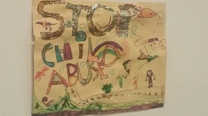 Painted sign saying Stop Child Abuse.