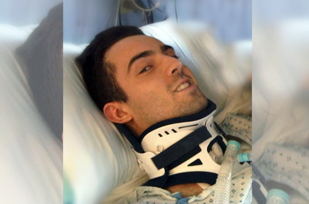 Ryan Atkins in a neck brace in the hospital
