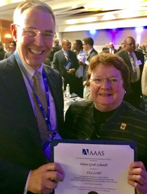 A close-up of a man standing next to a woman holding a certificate.