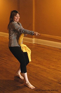 Woman tugging on a band to stretch out back and leg muscles 